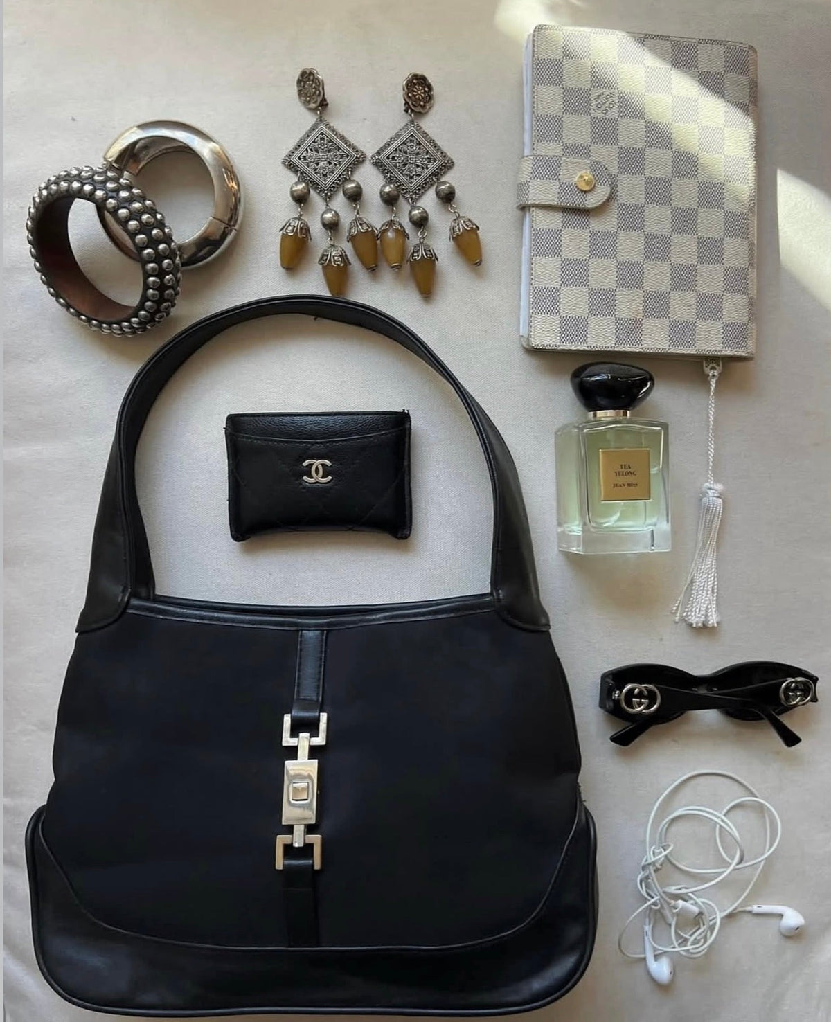 Flat lay of a black shoulder bag and accessories